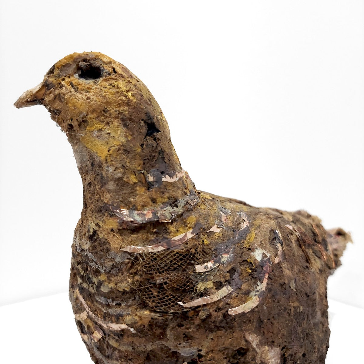 Rust-colored bird figurine on a white background